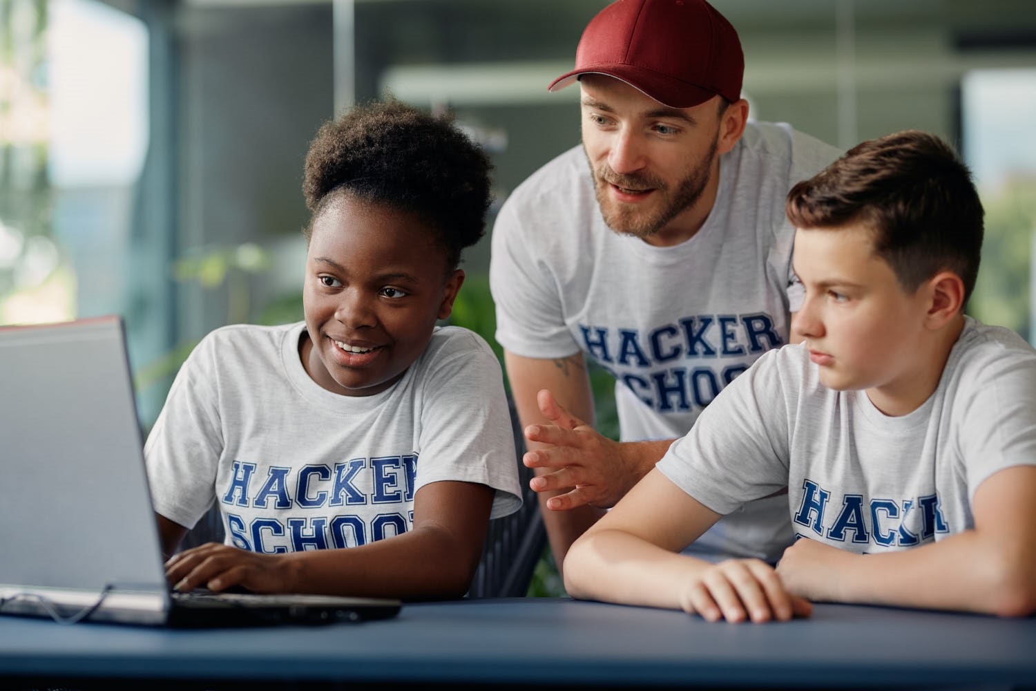 Ein Lehrer der Hacker School bringt zwei Kindern das Programmieren bei.