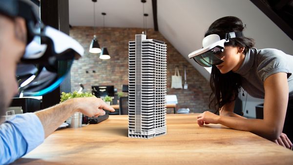 Zwei Personen mit VR-Brillen arbeiten an einem Immobilienmodell