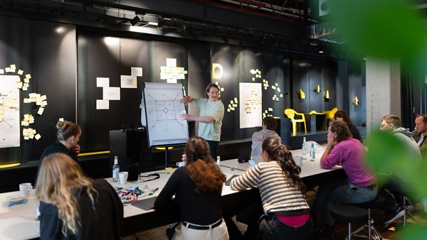 Workshop des Cross Innovation Hub: Ein Speaker erklärt etwas an einem Flipchart