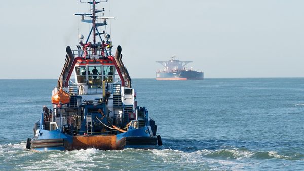 Schlepperboot auf dem Wasser mit anderen Schleppern im Hintergrund