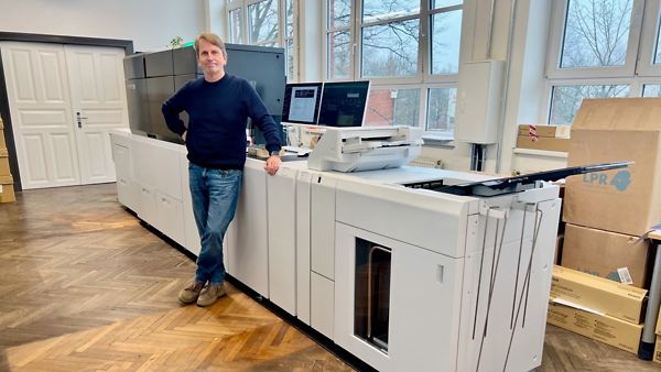 Geschäftsführer Holger Harms steht vor einem langen Drucker