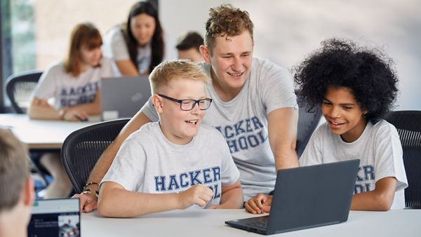 Ein Lehrer der Hacker School bringt zwei Kindern das Programmieren bei.