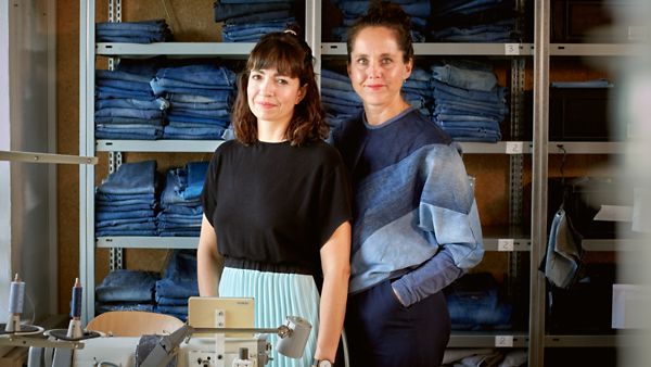 Die Gründerinnen Dr. Constanze Klotz und Hanna Charlotte Erhorn stehen vor einem Regal mit Jeans