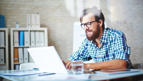 Ein bärtiger Mann am Laptop.